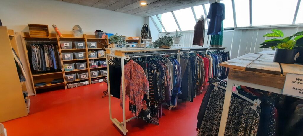 Kledingrekken en gelabelde bakken in de winkel